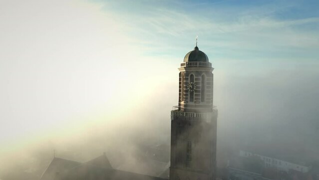 Peperbus tower of the The Roman Catholic Onze Lieve Vrouwe ten Hemelopneming-basilica church in Zwolle rising up above the fog.