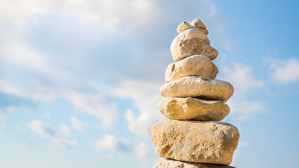 Fototapeta na wymiar Rock balancing with sky view and clouds on the background with space for design 