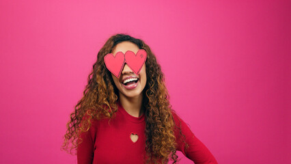 Happy silly woman poses with heart eyes, lovestruck infatuated emoji pink studio