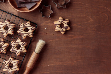 Fresh baked homemade star-shaped cookie with chocolate on the grid on the wooden table, copy space