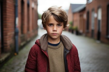 Portrait of a boy in a red jacket on the street.