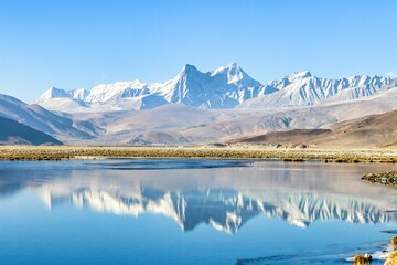 Peaceful lake with a reflection of the majestic mountain range in the background