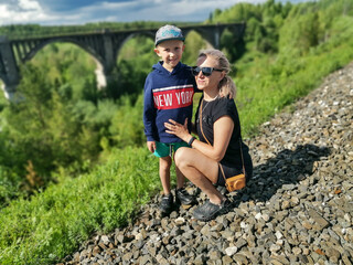 Railway bridge across the river in the south of the Kama region. A girl with a child on the...