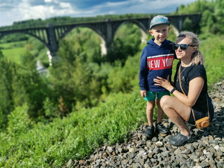 Railway bridge across the river in the south of the Kama region. A girl with a child on the...