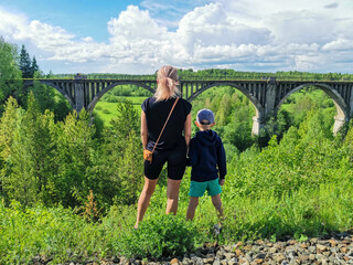 Railway bridge across the river in the south of the Kama region. A girl with a child on the...