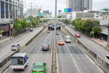 Image of traffic on a road running back and forth in a city in Bangkok. Thailand during daytime It's a bird's-eye view of every road. and a tunnel for cars to pass under the bridge.