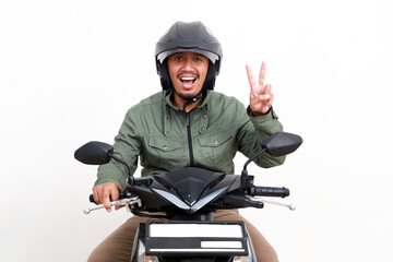 Happy asian man showing two fingers while driving motorcycle. Isolated on white background