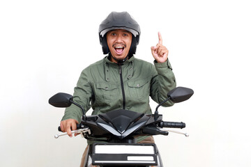 Excited asian man getting idea and showing a finger while driving motorcycle. Isolated on white background