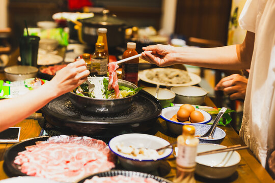 Group of friends cooking the Chinese shabu hotpot at home.