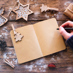 writes Christmas letter on wooden background