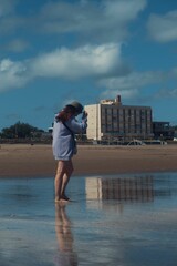 Barefoot woman walking along the sandy beach.