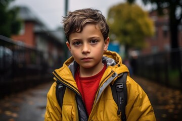 Portrait of a boy in a yellow jacket on the street.