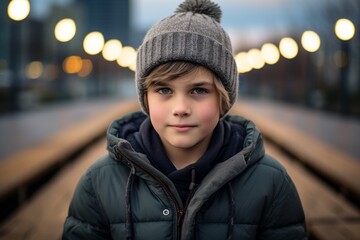 A portrait of a cute little boy in a winter hat and jacket.
