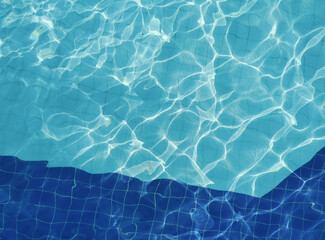 Sunshine through the clear ripple water. Swimming pool top view background. Relaxation in the summertime. Hotel and resort accommodation.