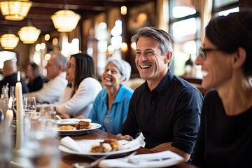 A diverse group of happy friends enjoying a meal together in a restaurant, showcasing cheerful conversation, laughter, and togetherness.