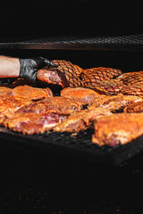 Chef hand cooking grilled beef meat in BBQ smoker