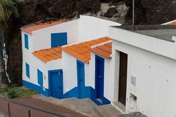 White building with a tiled roof and contrasting blue and orange colors. Formosa Beach, Madeira