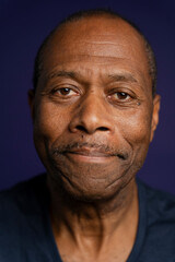 Portrait of smiling man with mustache against purple background