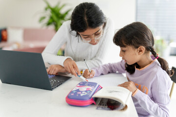 Girl helping little sister doing homework - obrazy, fototapety, plakaty