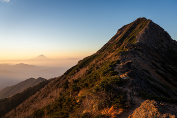 Fototapeta na wymiar 朝焼けに煙る富士と赤岳