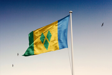 Saint Vincent and The Grenadines flag fluttering in the wind on sky. - obrazy, fototapety, plakaty
