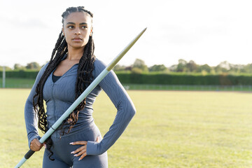 Portrait of confident female athlete holding javelin