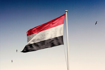 Yemen flag fluttering in the wind on sky.