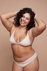 Studio portrait of smiling young woman wearing lingerie