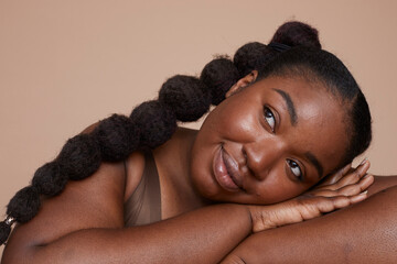 Studio shot of smiling young woman with braided hair - obrazy, fototapety, plakaty
