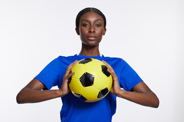 Studio portrait of woman holding soccer ball