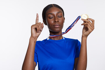 Studio portrait of athletic woman with golden medal © Cultura Creative