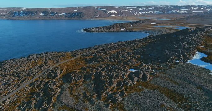 Aerial view of coast road 8100 to Hamningberg with rocky landscape in sunny summer weather, Varanger Peninsula, Norway.