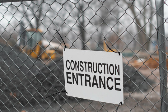 Construction site sign on fence and machinery working background, copy space image background