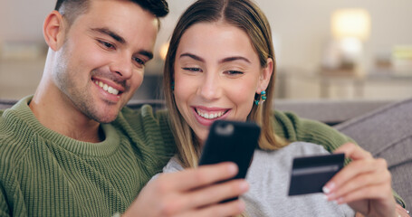 Couple, phone and credit card on couch in home for online shopping, sales or banking in living...
