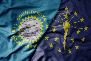 big waving colorful national flag of indiana state and flag of south dakota state .