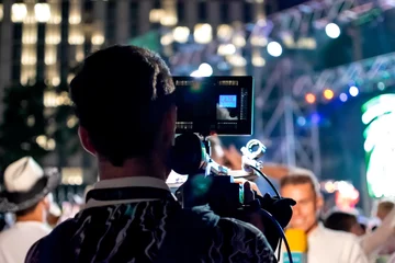 Fototapeten Camera man recording television reporter at live event © CarlosMSubirats