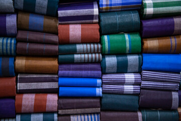 Multicolor Traditional Bangladeshi men's wear lungi folded on a rack in a store. Can be used as  pattern texture background wallpaper