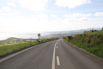Scenic view of a long asphalt road in the middle of fields in the countryside