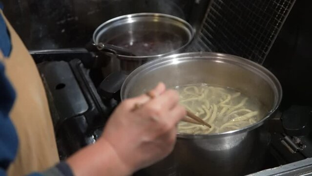 蕎麦を茹でる女性