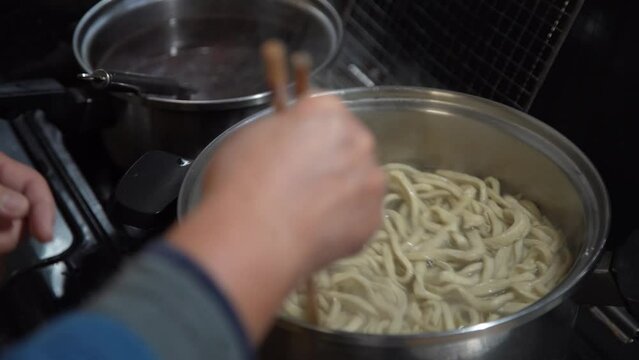 蕎麦を茹でる女性