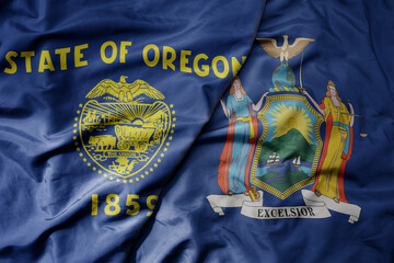 big waving colorful national flag of new york state and flag of oregon state .