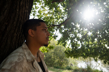 Portrait of man relaxing in park on sunny day