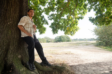 Portrait of man relaxing in park on sunny day