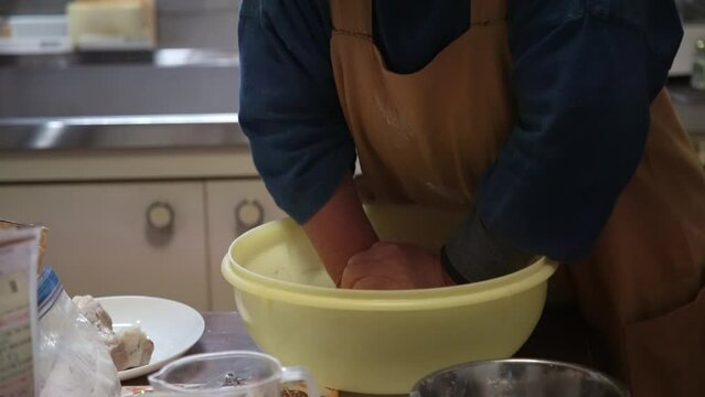 自宅でそばを打つ女性