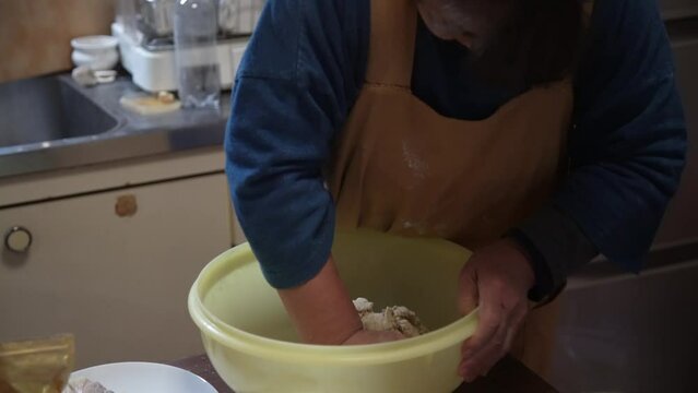 自宅でそばを打つ女性