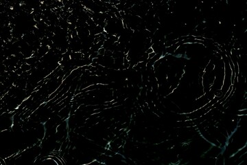 Bluewater waves on the surface ripples blurred. Defocus blurred transparent blue colored clear calm water surface texture with splash and bubbles. Water waves with shining pattern texture background.