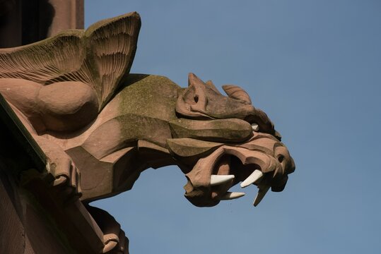 Closeup of intricately carved stone statue mounted above a brick wall in Lichfield Cathedral, UK