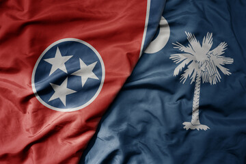 big waving colorful national flag of south carolina state and flag of tennessee state .