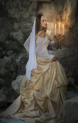A beautiful red-haired girl in an old medieval dress with swords stands in the mountains and looks into the distance. Fairytale story about a princess. magic light. Warm artistic work. © olenakucher