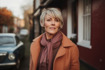 Portrait of a beautiful middle-aged woman in a coat and scarf on the street